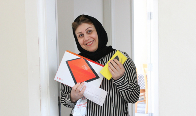 Happy woman holding a tablet and phone