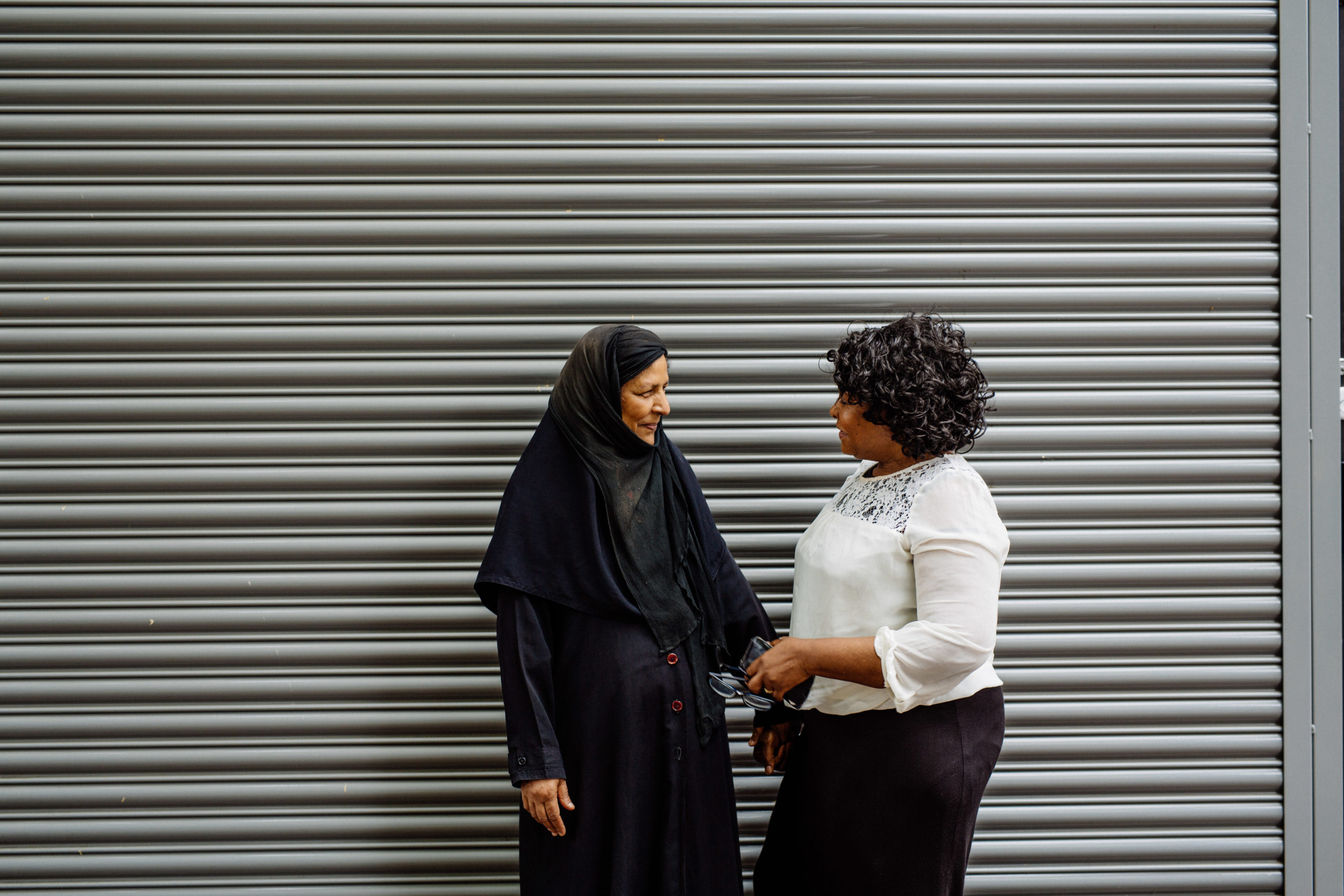 Two women talking in front of a stripy background